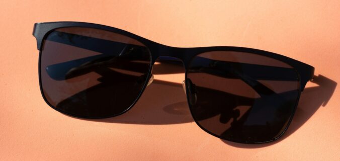 black framed sunglasses on white table