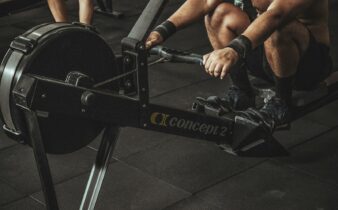 topless man using rowing machine