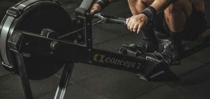 topless man using rowing machine