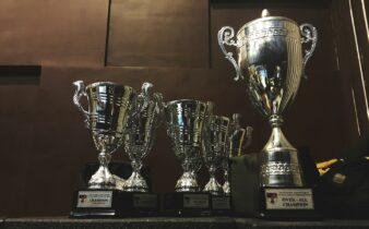 several silver and gold trophies on wooden surface