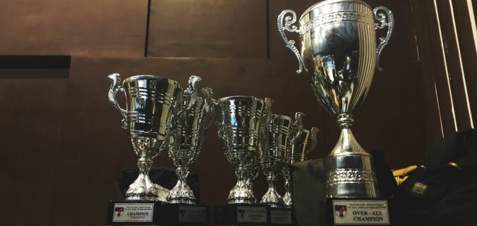 several silver and gold trophies on wooden surface