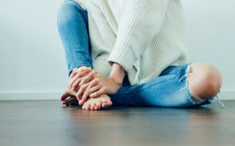 person wearing distressed blue denim jeans inside room