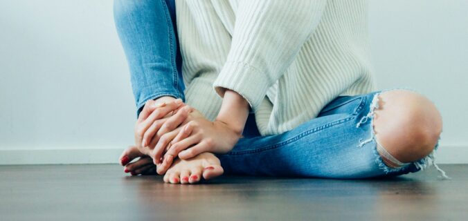 person wearing distressed blue denim jeans inside room